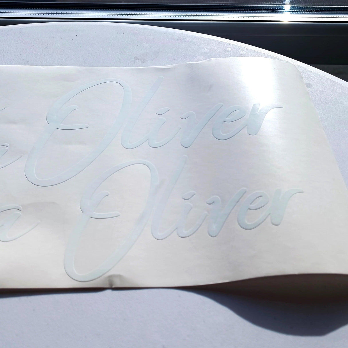Personalized vinyl name decal with the name 'Oliver' displayed on a smooth surface.