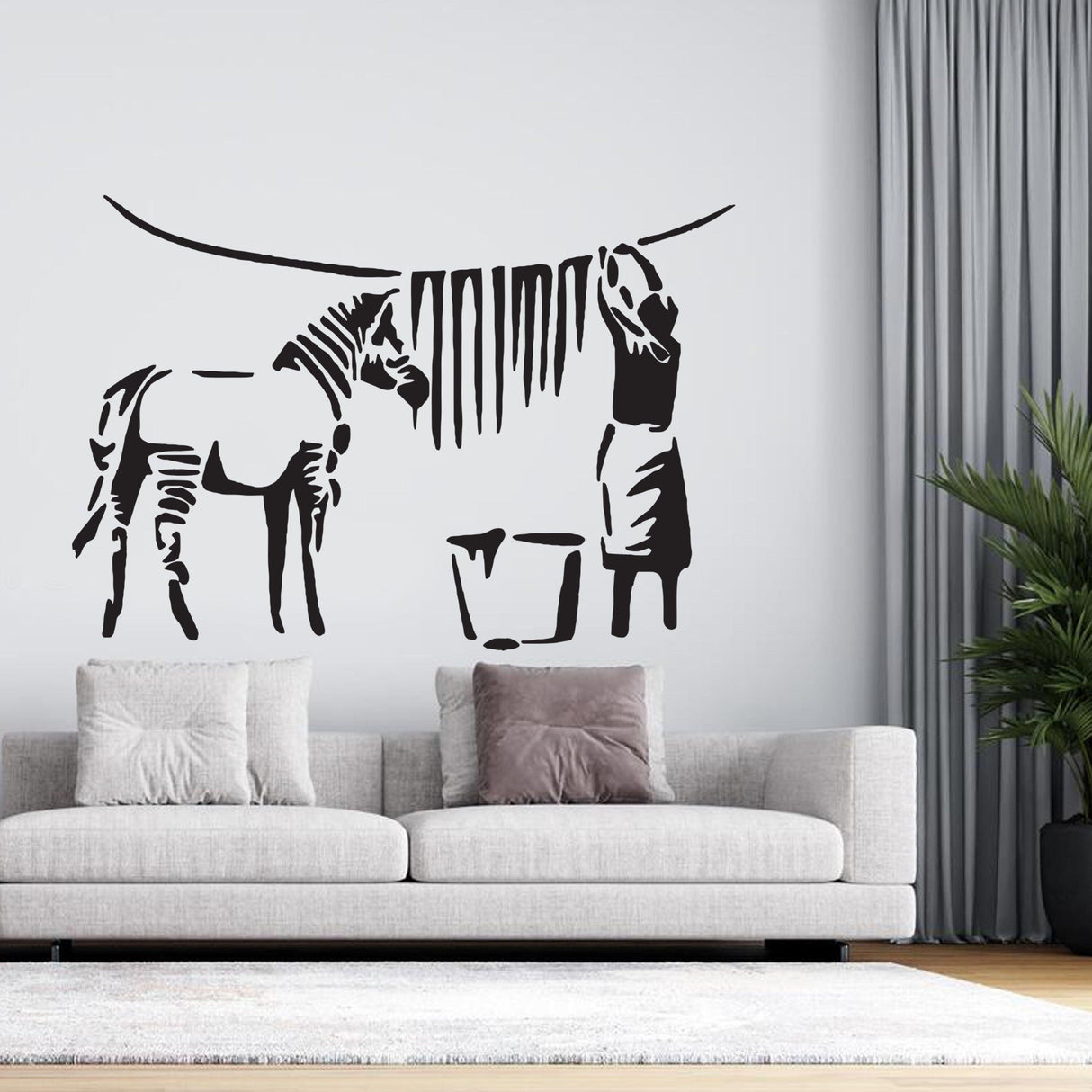 Banksy zebra stripes wall decal in a modern living room, featuring playful urban street art design with a person and a zebra.