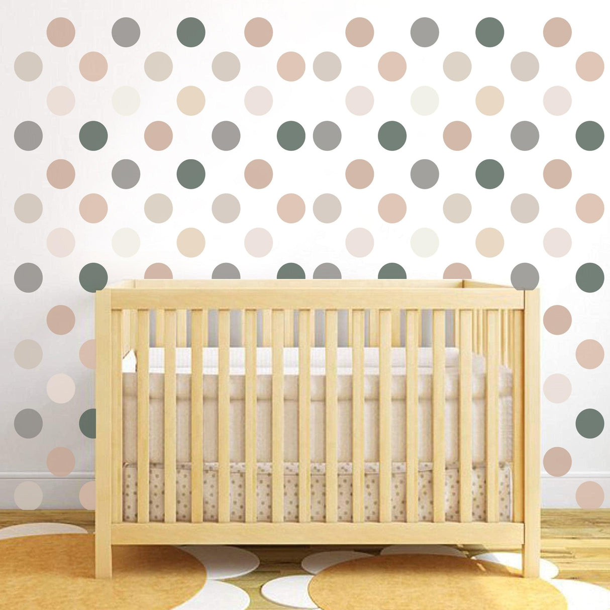 50x neutral boho dots decals on nursery wall above wooden crib, pastel circle stickers decor for baby room.