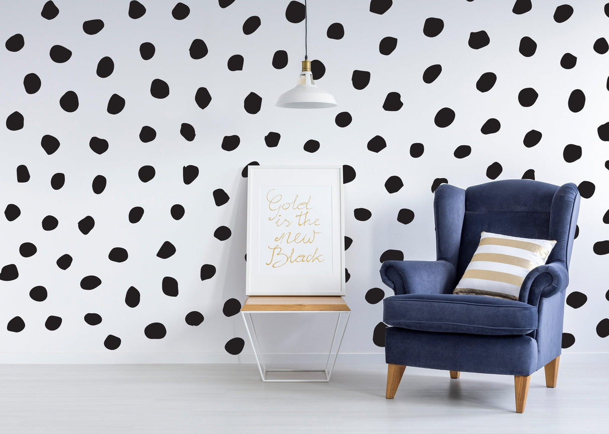 Modern living room with black polka dot wall decals and a cozy blue armchair.