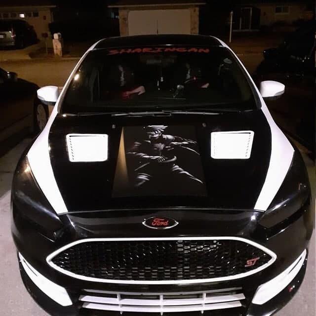 Custom decorated Ford car with a striking graphic on the hood and unique black and white design.