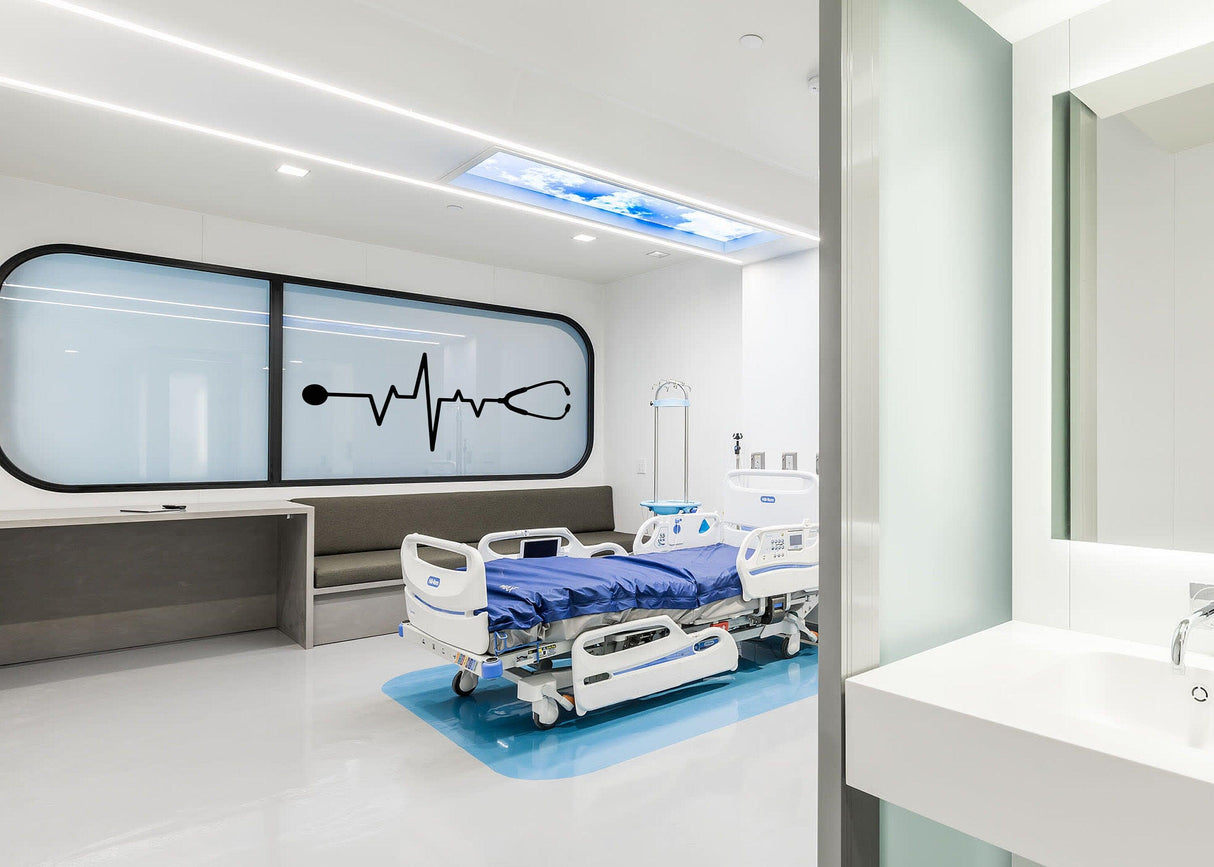 Modern hospital room with a heartbeat design wall decal, featuring a hospital bed and sleek furnishings.