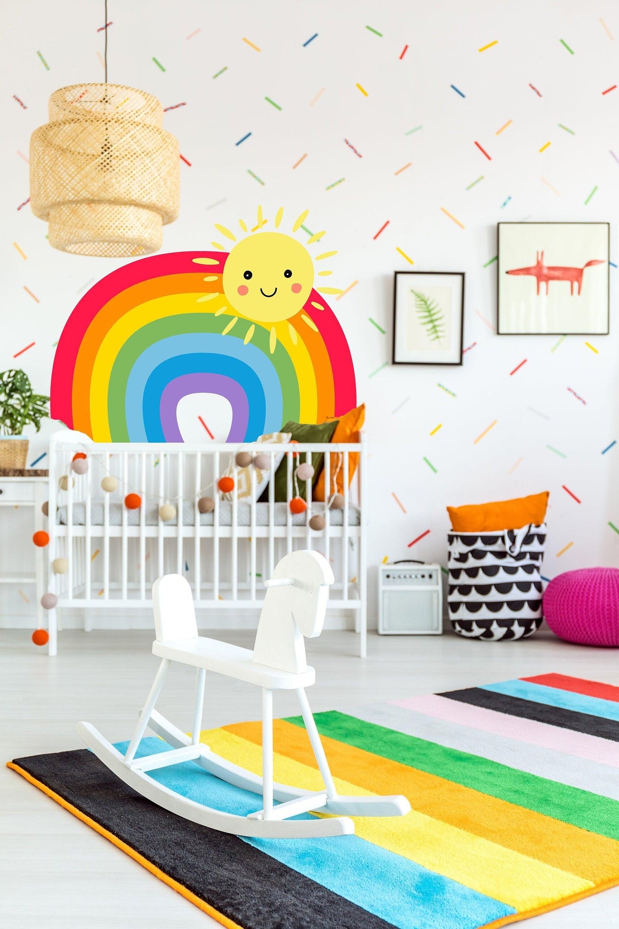 Colorful nursery with rainbow wall sticker, cheerful sun decal, and playful decor for baby's room.