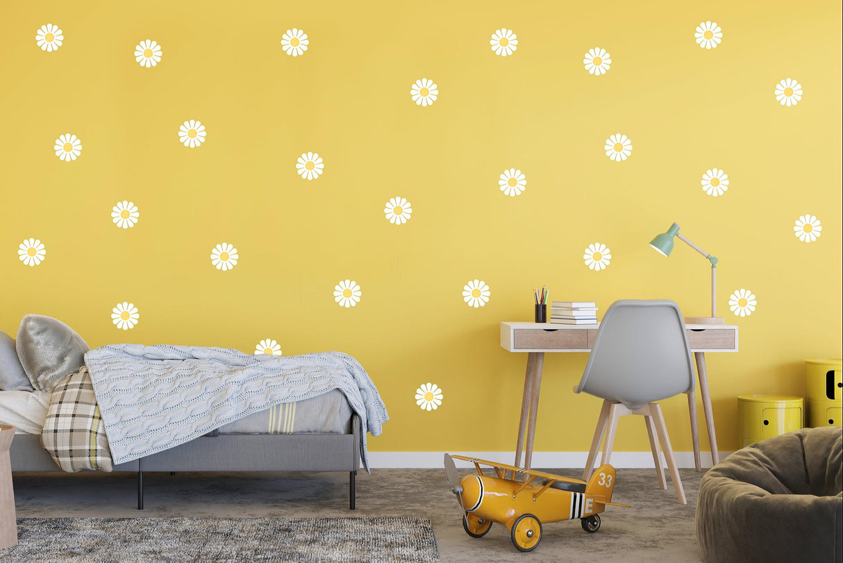 Elegant white daisy flower wall decals on a sunny yellow wall in a cozy bedroom setting.