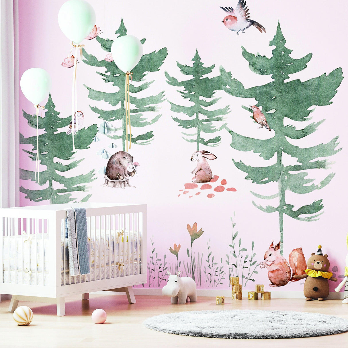 Forest animals and watercolor trees wall decal in kids nursery, with balloons and a crib.
