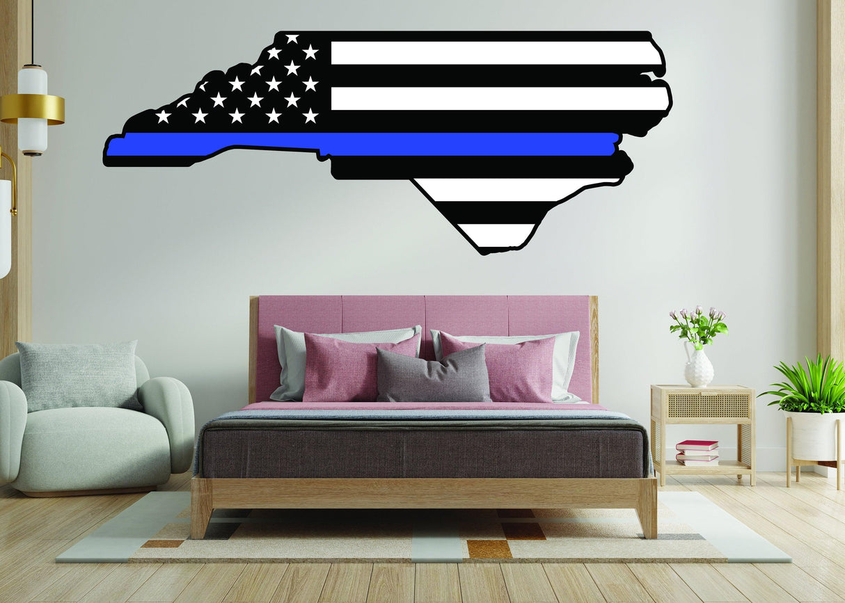 North Carolina state silhouette decal with American flag design, featuring blue line for decor in modern bedroom setting.