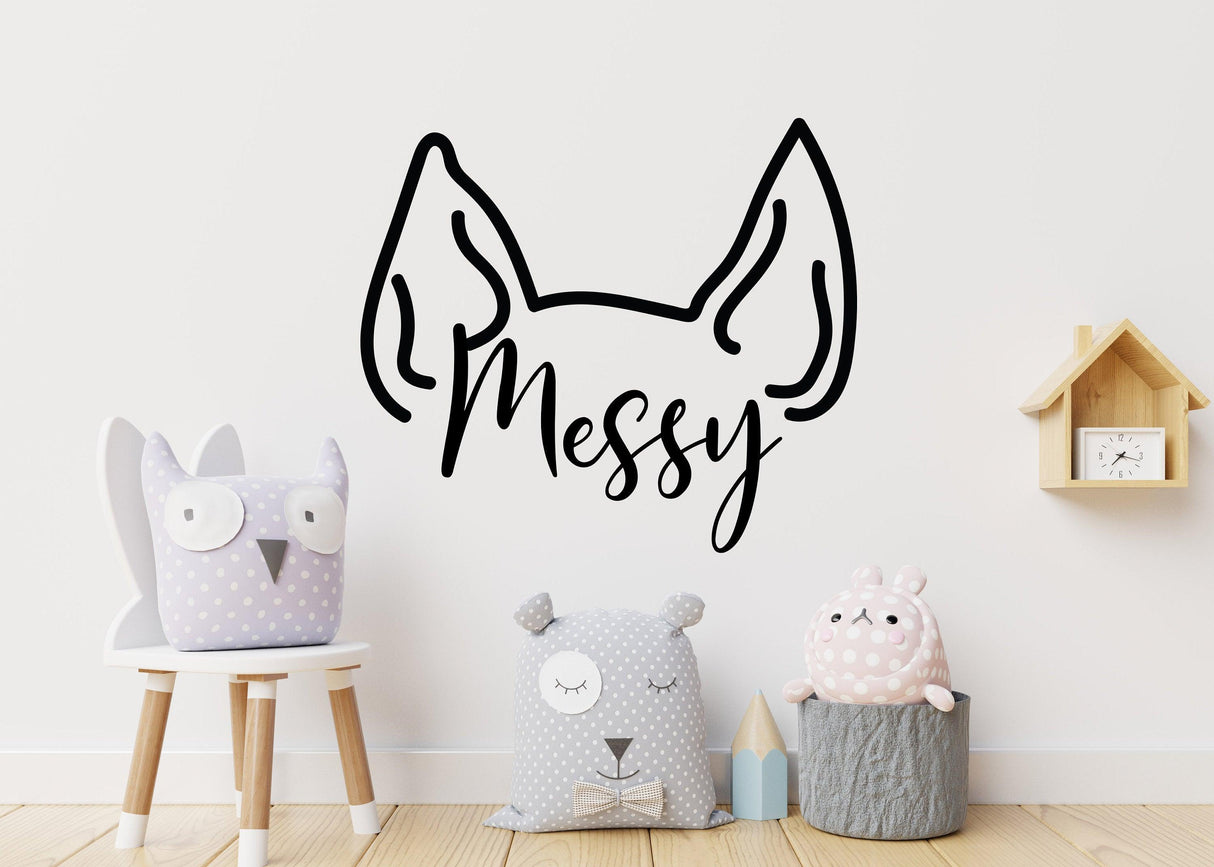 Custom pet ear wall decal saying 'Messy' above cute plush animals in a playful room setting.