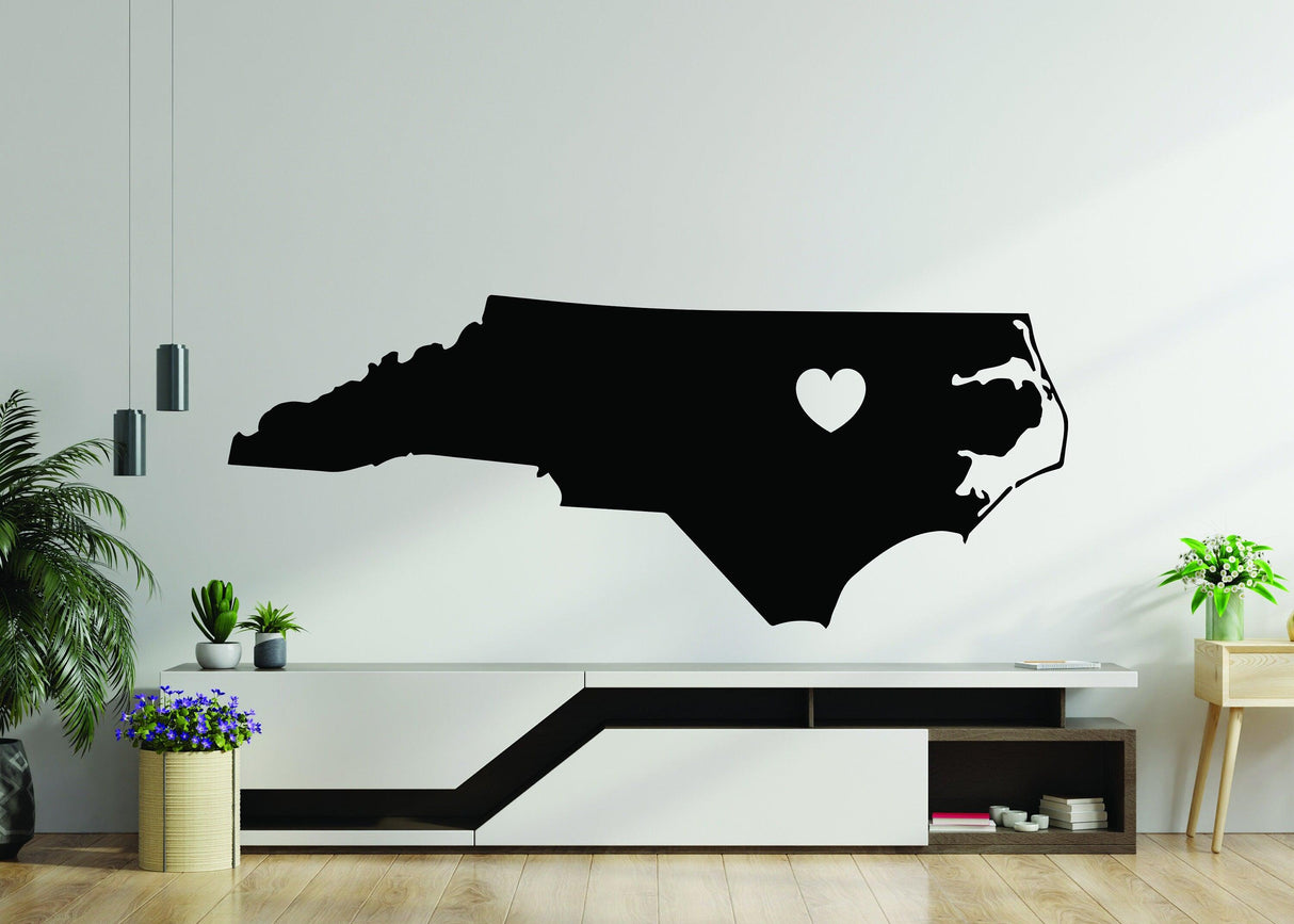 Black North Carolina state silhouette vinyl decal with heart design, perfect for home decor.