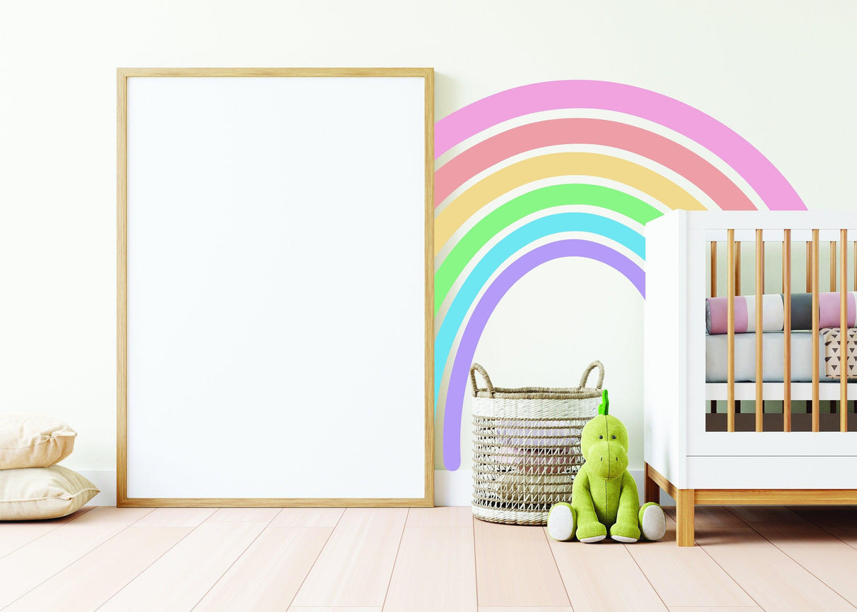 Charming boho rainbow wall sticker in nursery with green toy and wooden crib, adding whimsy to the decor.