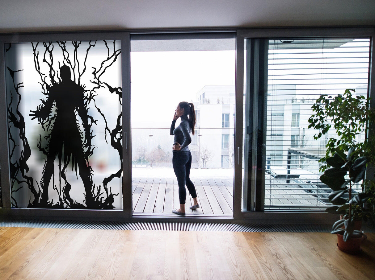 Frosted vampire silhouette decal on glass door with a woman standing nearby, adding gothic elegance to home decor.