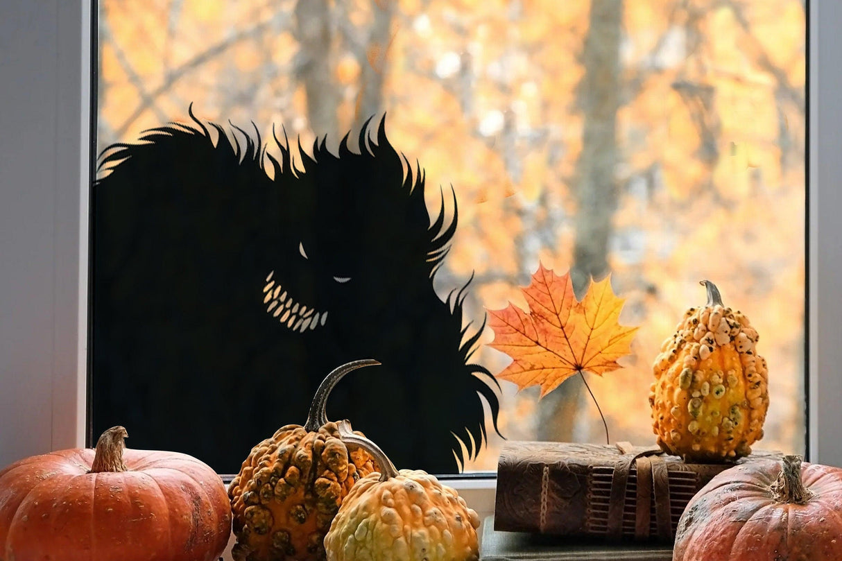 Creepy Halloween monster window decal with pumpkins and autumn leaves in the foreground.