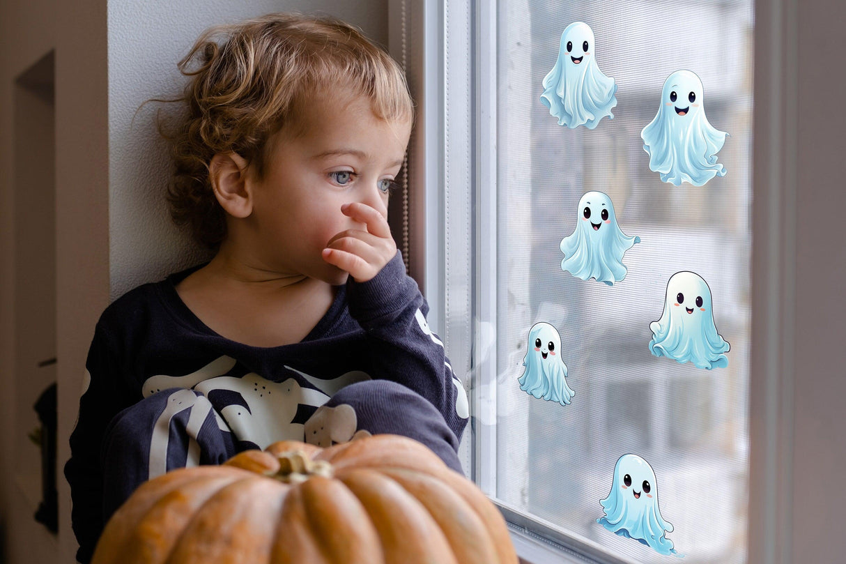 Child looking at playful ghost window decals with pumpkin, perfect for Halloween decor.