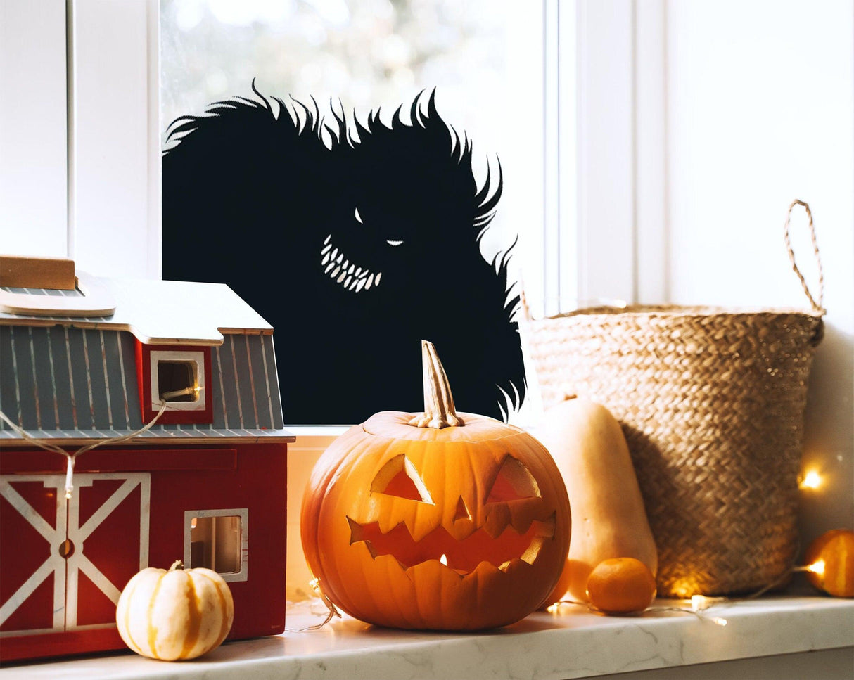 Spooky Halloween monster window decal with a creepy silhouette, featuring a menacing figure behind a pumpkin and decorations.