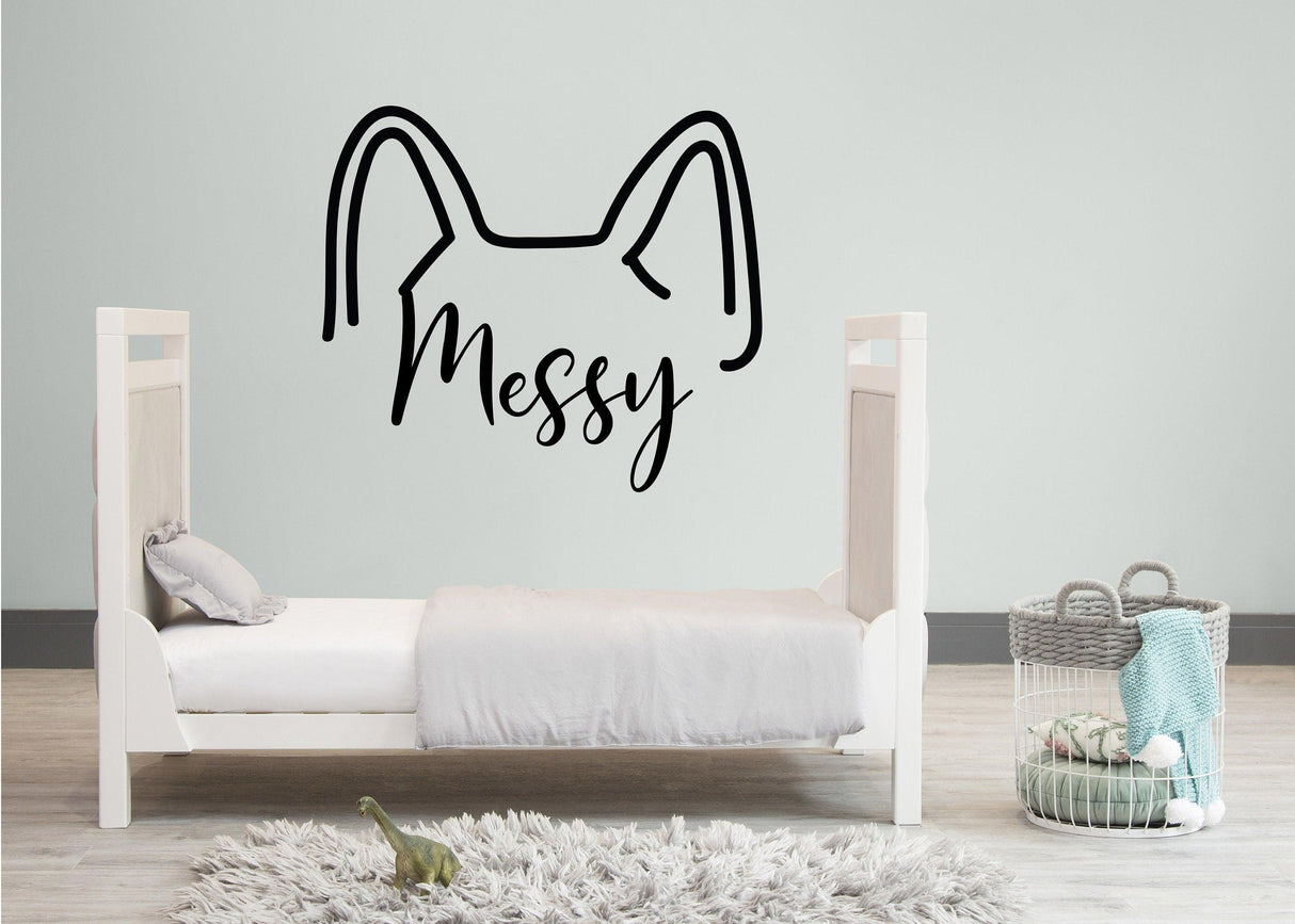 Custom dog ears decal with the word 'Messy' above a children's bed, adding playful decor to the room.