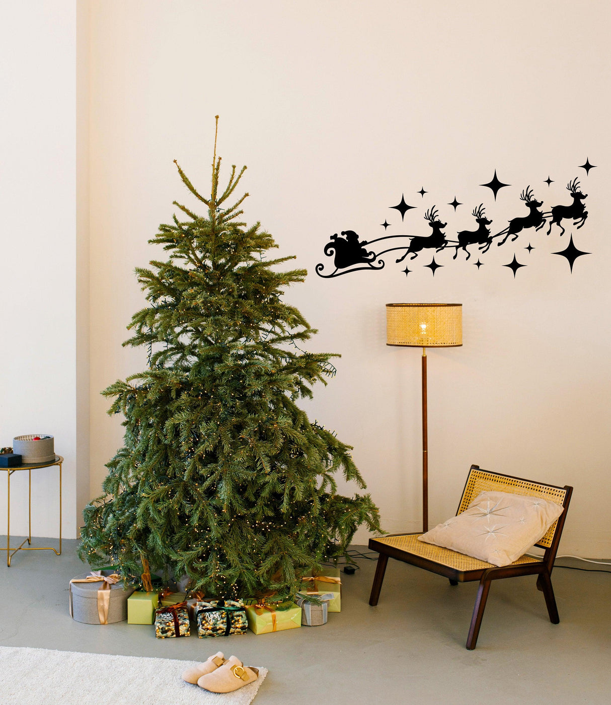 Santa sleigh with reindeer wall decal above a decorated Christmas tree in a cozy living room.
