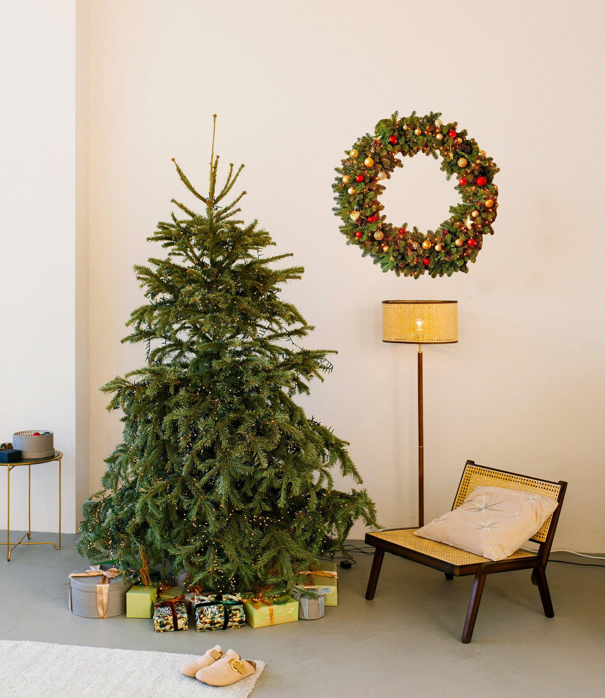 Christmas wreath wall decal above a decorated tree with presents, festive holiday decor in a cozy living space.