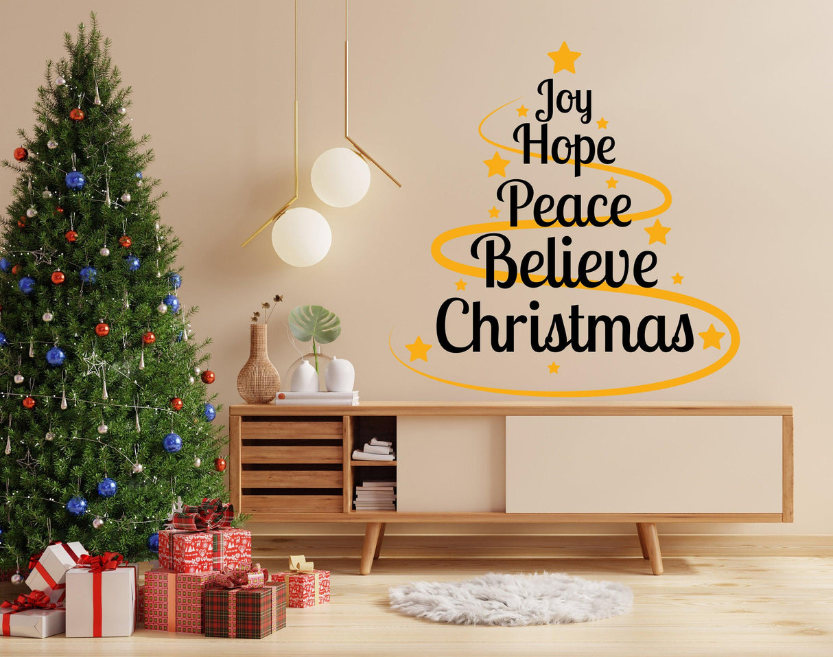 Colorful vinyl sticker with Christmas quote 'Joy Hope Peace Believe Christmas' on a living room wall.
