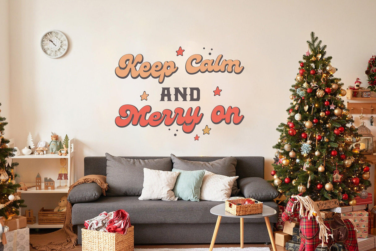Whimsical Christmas wall decal saying 'Keep Calm and Merry On' above a cozy sofa and decorated Christmas trees.