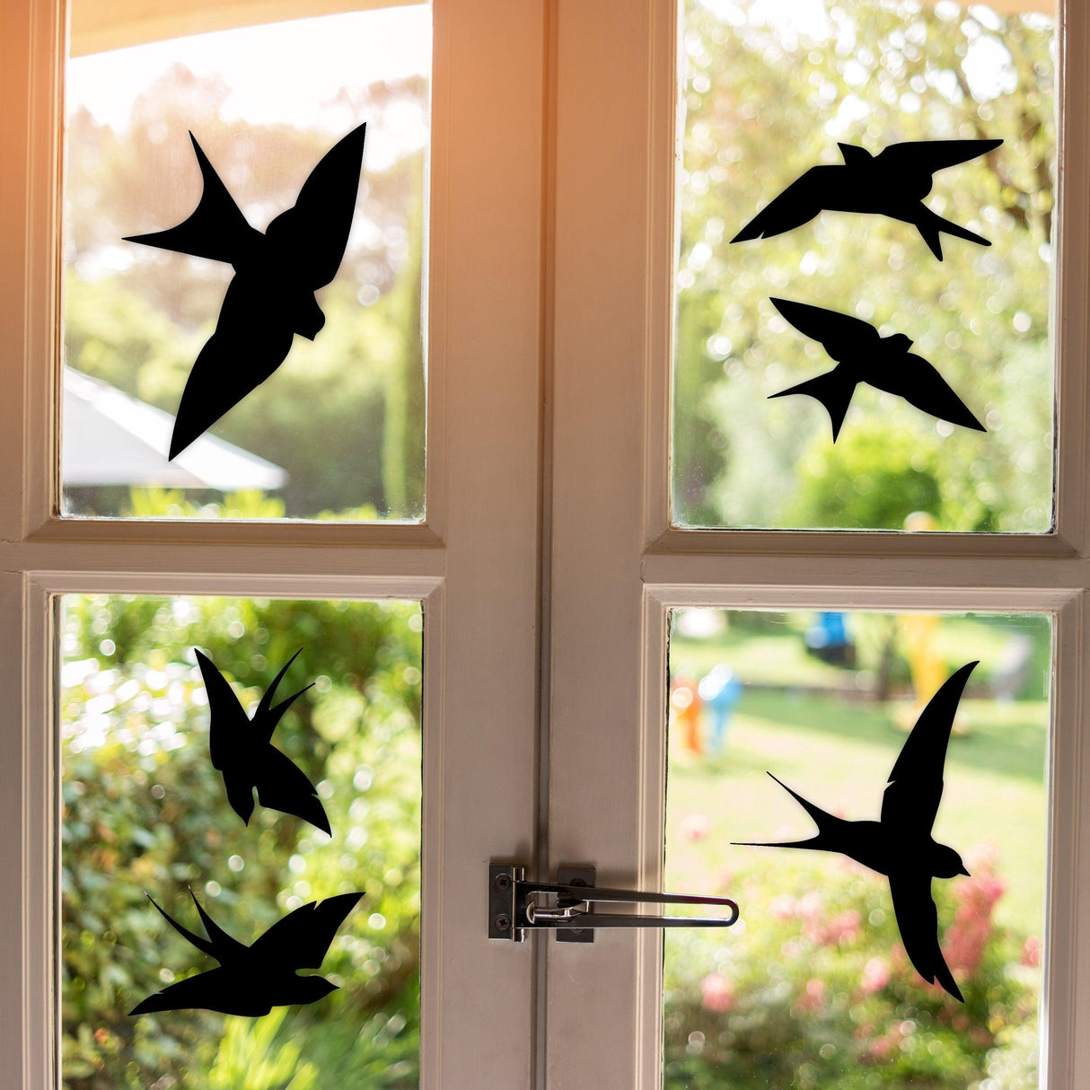 Black bird silhouette decals on windows to prevent bird collisions and enhance safety outdoors.