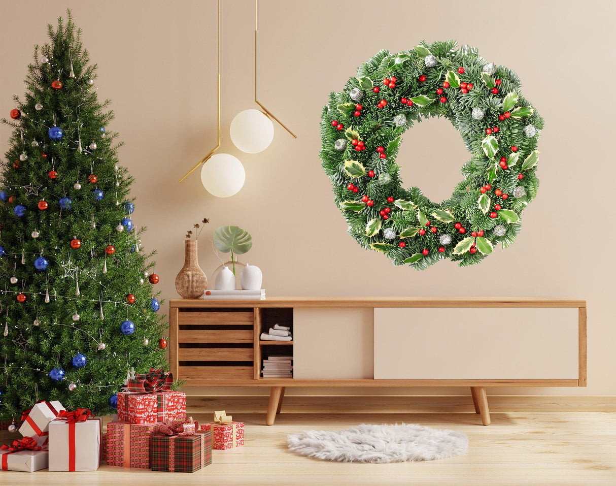 Green Christmas wreath wall decal with red berries on a beige wall, festive decor around a Christmas tree.