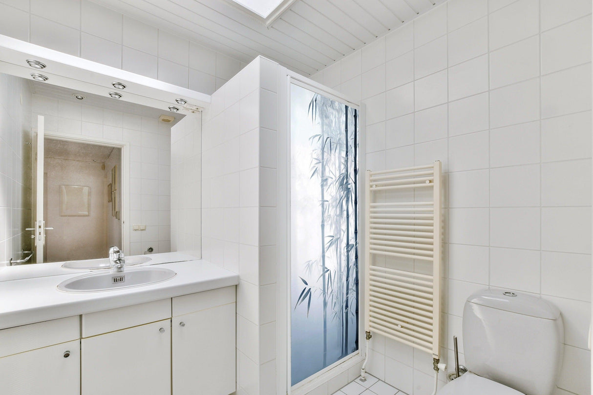 Bright bathroom featuring a serene glass shower door sticker with a tranquil bamboo forest design.