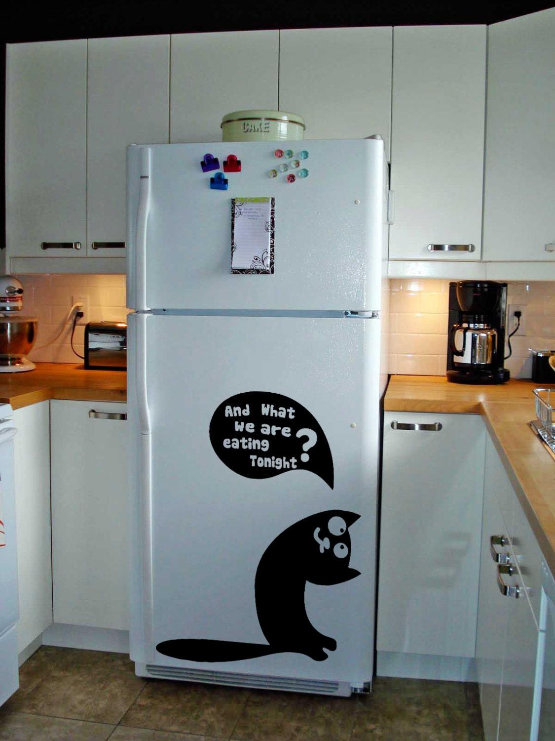 Cute vinyl sticker on fridge featuring a cat and the text 'And what we are eating tonight?' in a modern kitchen.