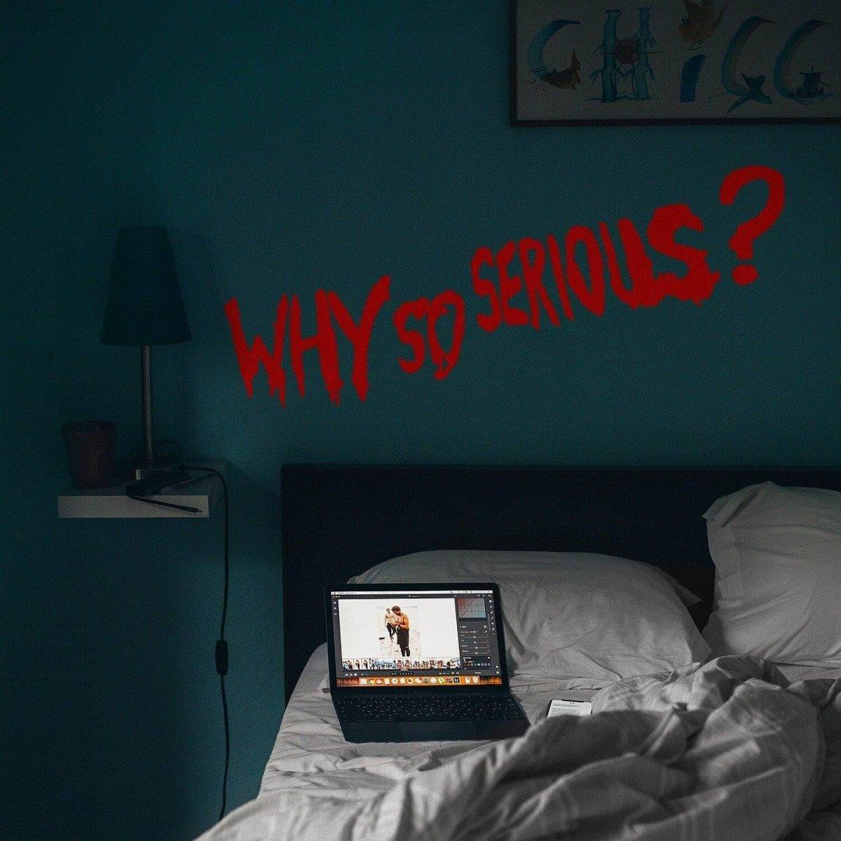 Mischief-themed vinyl wall decal saying 'WHY SO SERIOUS?' above a bed with a laptop on the covers.
