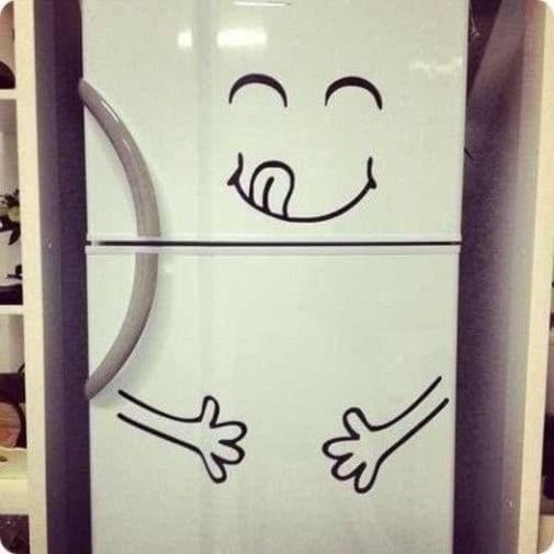 Playful vinyl die cut sticker on a kitchen fridge, featuring a smiling face and playful hands design.