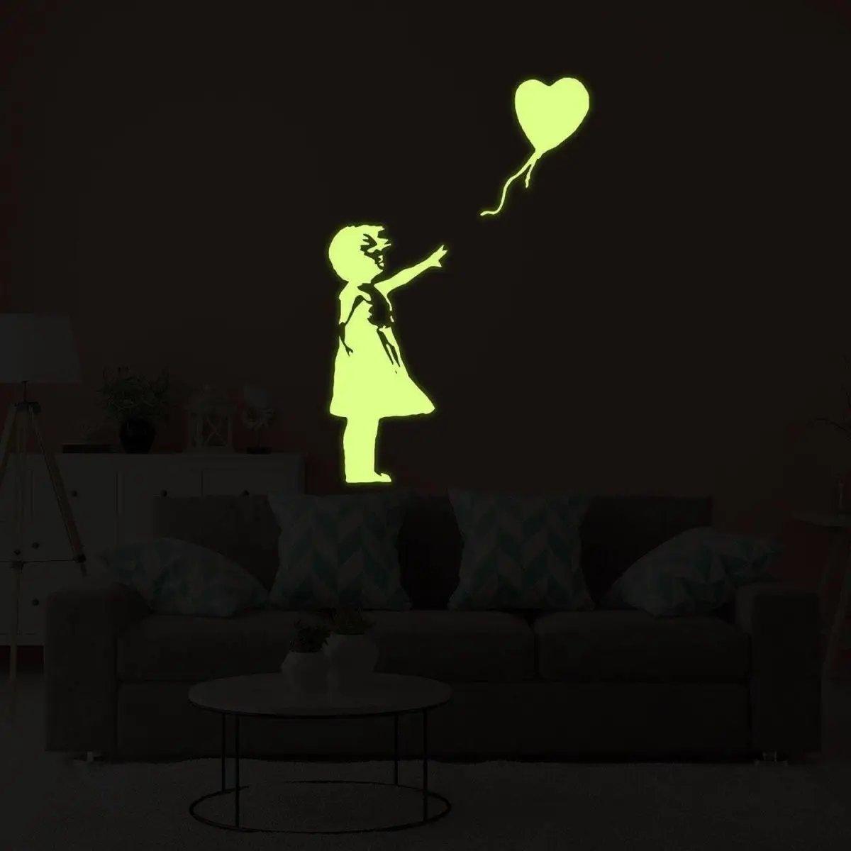 Glow in the dark vinyl sticker of a girl with a heart balloon, perfect for adding magical decor to any room.