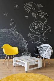 Creative chalkboard wall with astronaut and rocket drawings, featuring stylish furniture and vibrant decor.