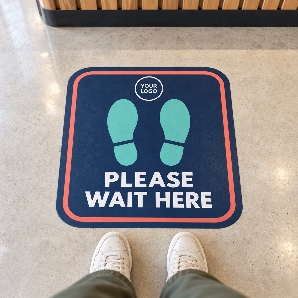 Example of a personalized Please Wait Here floor decal with footprints and a logo placeholder