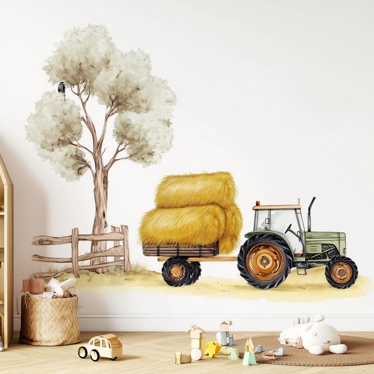 A watercolor-style wall decal in a nursery showing a green tractor pulling a hay-loaded trailer beside a large tree and wooden fence, with scattered toys and a plush bunny on the floor nearby.