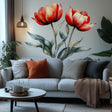 Two large red watercolor tulips with green leaves displayed as a wall decal above a modern light gray couch in a cozy living room setting.
