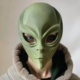 3D printed alien face mask with smooth organic shape, worn by an adult model indoors, realistic sci-fi costume accessory made from matte PLA plastic