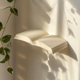 3D printed wall shelf shaped like an open book, mounted on a wall with soft natural light, minimalist modern home decor accessory