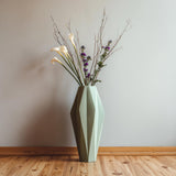 Tall geometric 3D printed vase with faceted design, displayed with dried flowers and branches in a minimalist modern interior