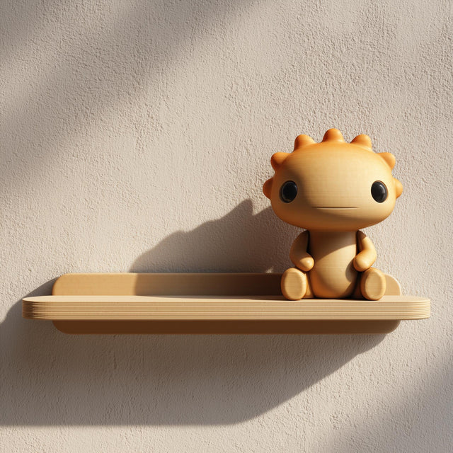 3D printed wall shelf with a small sun-like character sitting on a slim tray-style ledge, made from matte PLA plastic and mounted on a textured wall beside leaves.