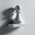 3D printed wall shelf with a large minimalist chess pawn integrated into a small rectangular ledge, made from matte PLA plastic on a light wall.