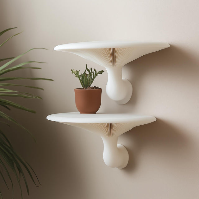 &quot;Pair of white 3D printed mushroom-inspired wall shelves mounted on a neutral wall, styled with a terracotta potted cactus.&quot;