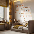Large wall decal featuring a family of four cute stylized cats in cream and orange tones, creating a cozy and warm atmosphere in a modern children's bedroom or nursery.