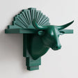 3D printed bull head wall shelf with long horns and an art deco fan-shaped backplate, forming a floating ledge on a minimalist wall.
