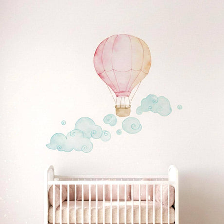 A soft watercolor illustration of a pink and pale orange hot air balloon floating above several whimsical, swirling teal and light green clouds on a plain white background.