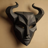 3D printed dark fantasy horned mask wall decor with sharp geometric facial planes and curved horns, mounted on a warm neutral wall.