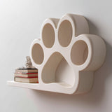 3D printed paw print shaped wall shelf with integrated small display platform, mounted on a light minimalist interior wall.