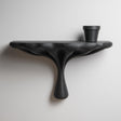 3D printed modern organic wall shelf with smooth sculptural support and matte black finish, mounted on a light minimalist interior wall.
