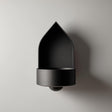 3D printed arched wall mounted shelf with a pointed backplate and a small integrated bowl tray, minimalist sculptural design on a clean wall.