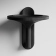 3D printed wall mounted bowl shelf with a wide round tray and sculptural vertical support, visible print texture, mounted on a clean studio wall.