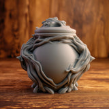 3D printed goblincore woodland memorial urn with sculpted twisting roots, organic forest details, and removable lid on a wooden table.