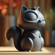 Dark gray 3D printed squirrel memorial urn with removable lid, closed eyes, small nose, pointed ears, curled tail, paws, and bow detail on top.