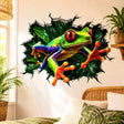 3D broken wall vinyl decal featuring a weird colorful tree frog with big red eyes reaching forward in a lush green rainforest background.